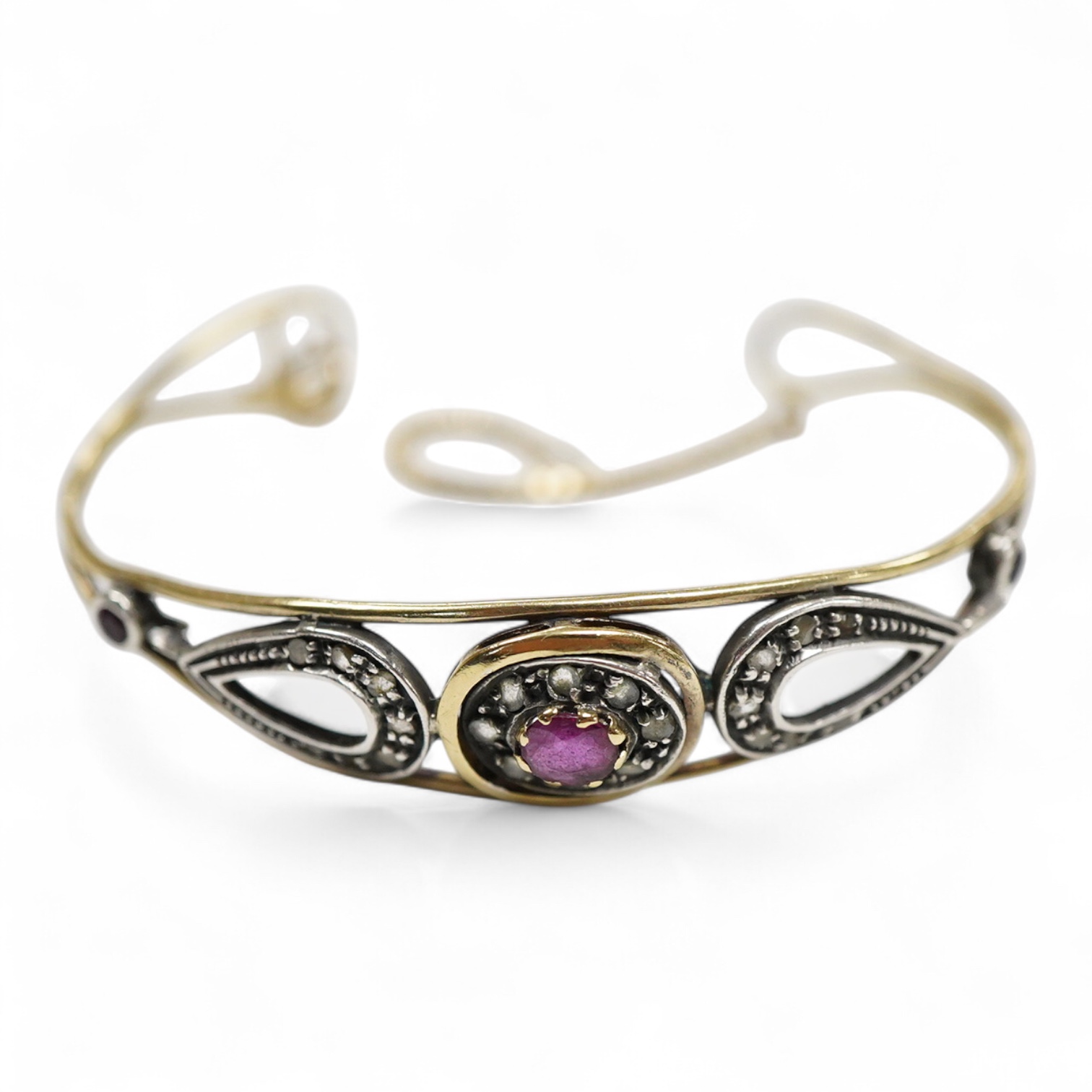 An Italian 18k and white metal, ruby and diamond cluster set bangle, with safety chain, gross weight 10.1 grams.